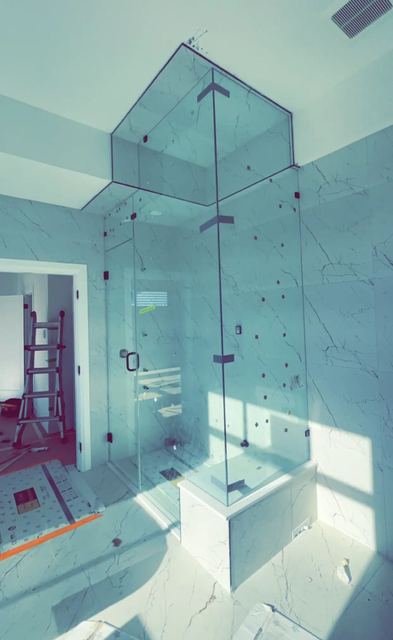 Frameless glass shower enclosure installed by Sparkle Glass