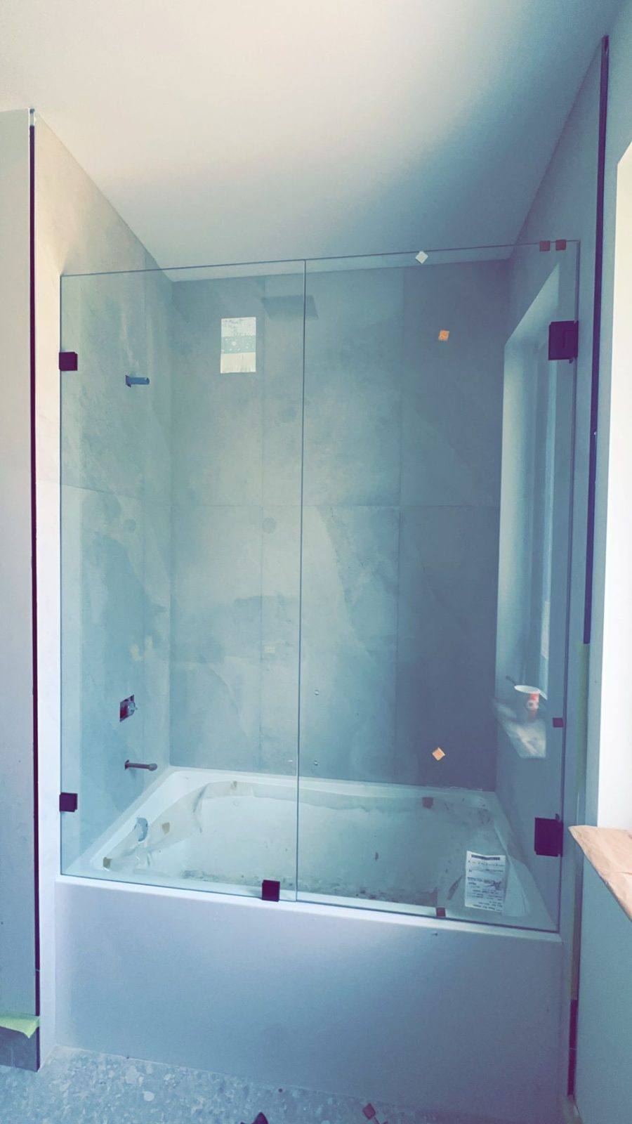 Frameless hinged shower door installed by Sparkle Glass technicians